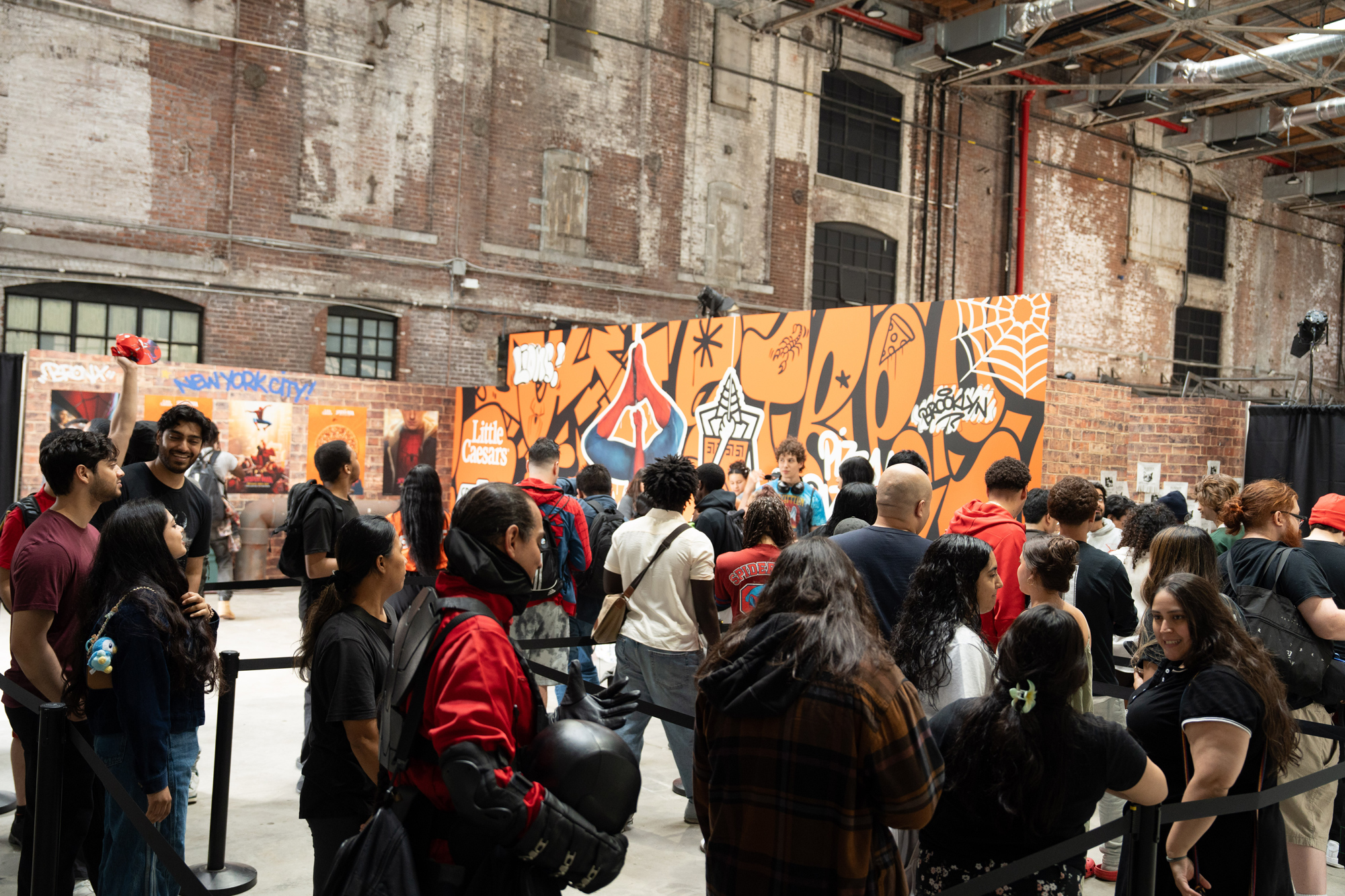Fans queuing in front of the graffiti container wall inside the warehouse
