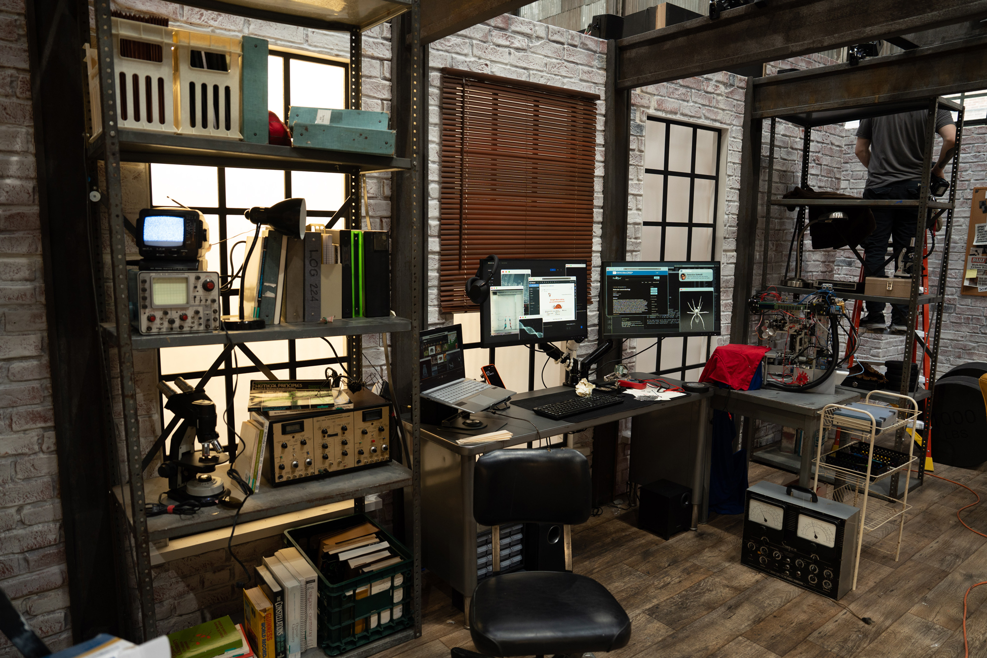 Peter Parker's apartment desk set dressing with multiple monitors and hacking props