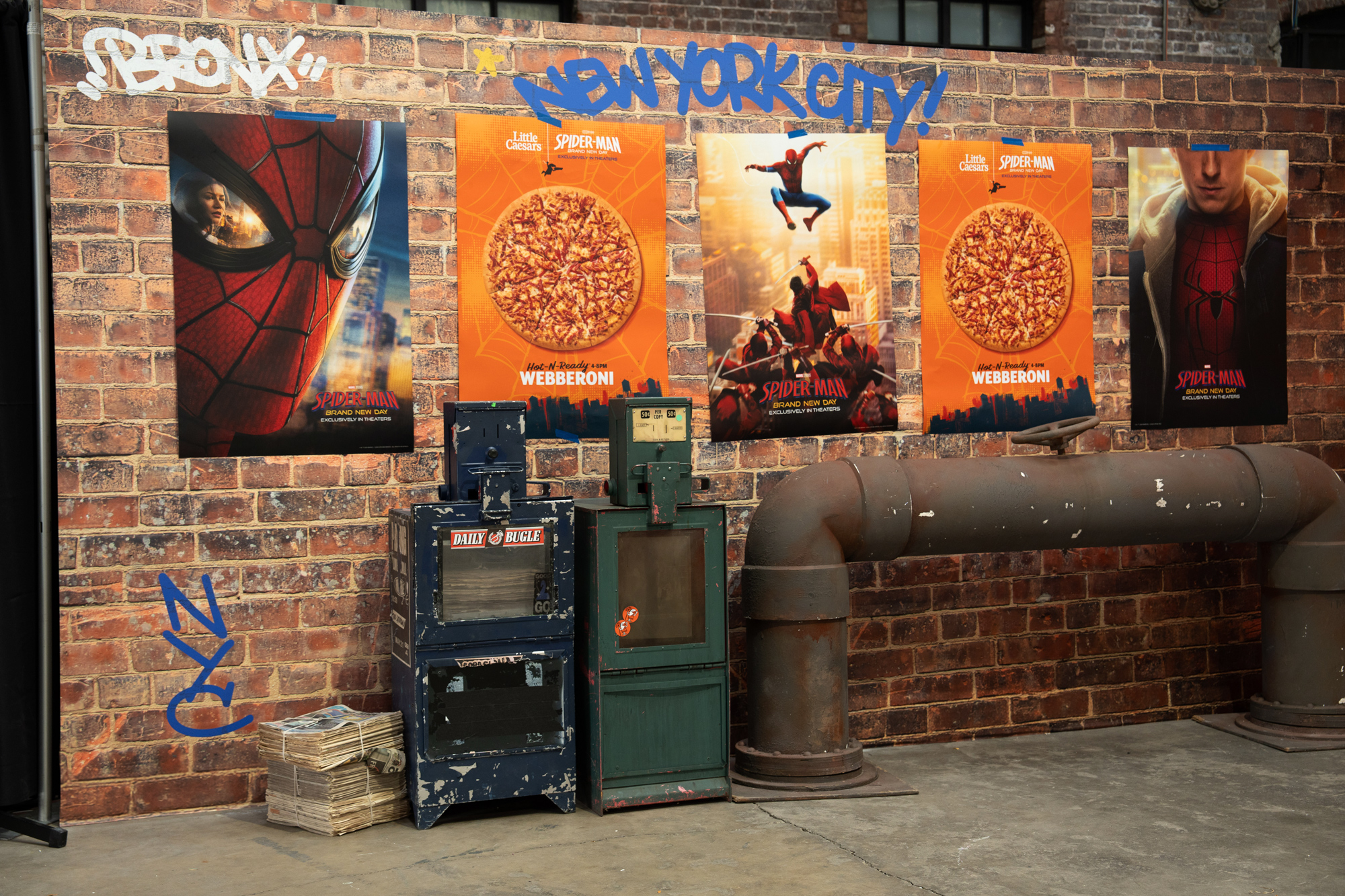 Brick wall dressed with Spider-Man and Webberoni one-sheets and a Daily Bugle newsstand prop